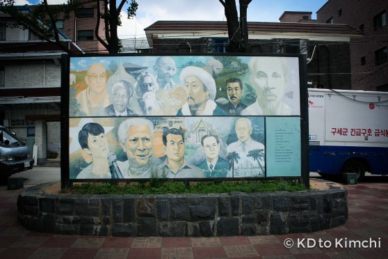A faded mural of famous Asian icons in the park